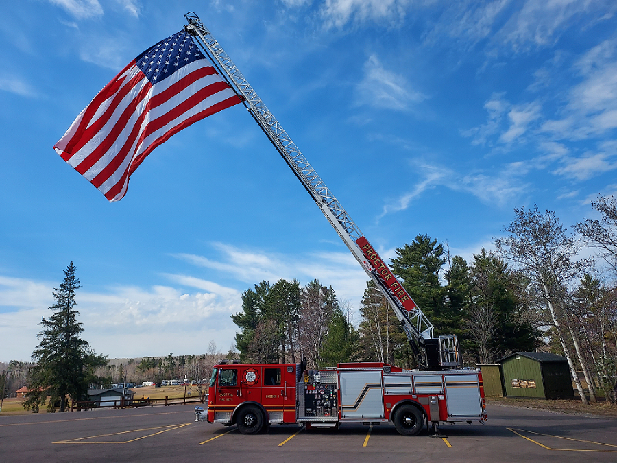 Proctor Fire Engine with an American Flag on it's ladder